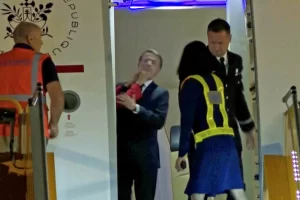 French president Emmanuel Macron addresses his wife shoving him in the face on aircraft